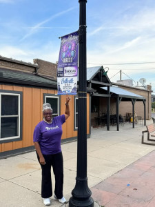 The Executive Director of SOOAR with a street banner